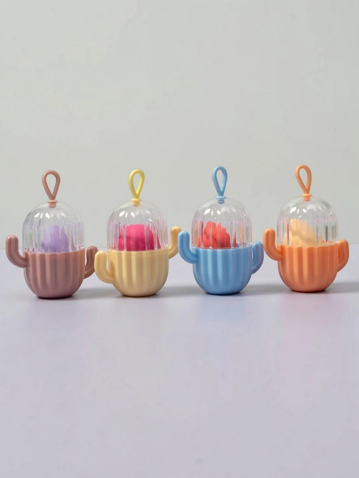 Miso station cactus shaped cosmetic sponge holders in pastel pink, yellow, blue, and orange with clear vented lids.