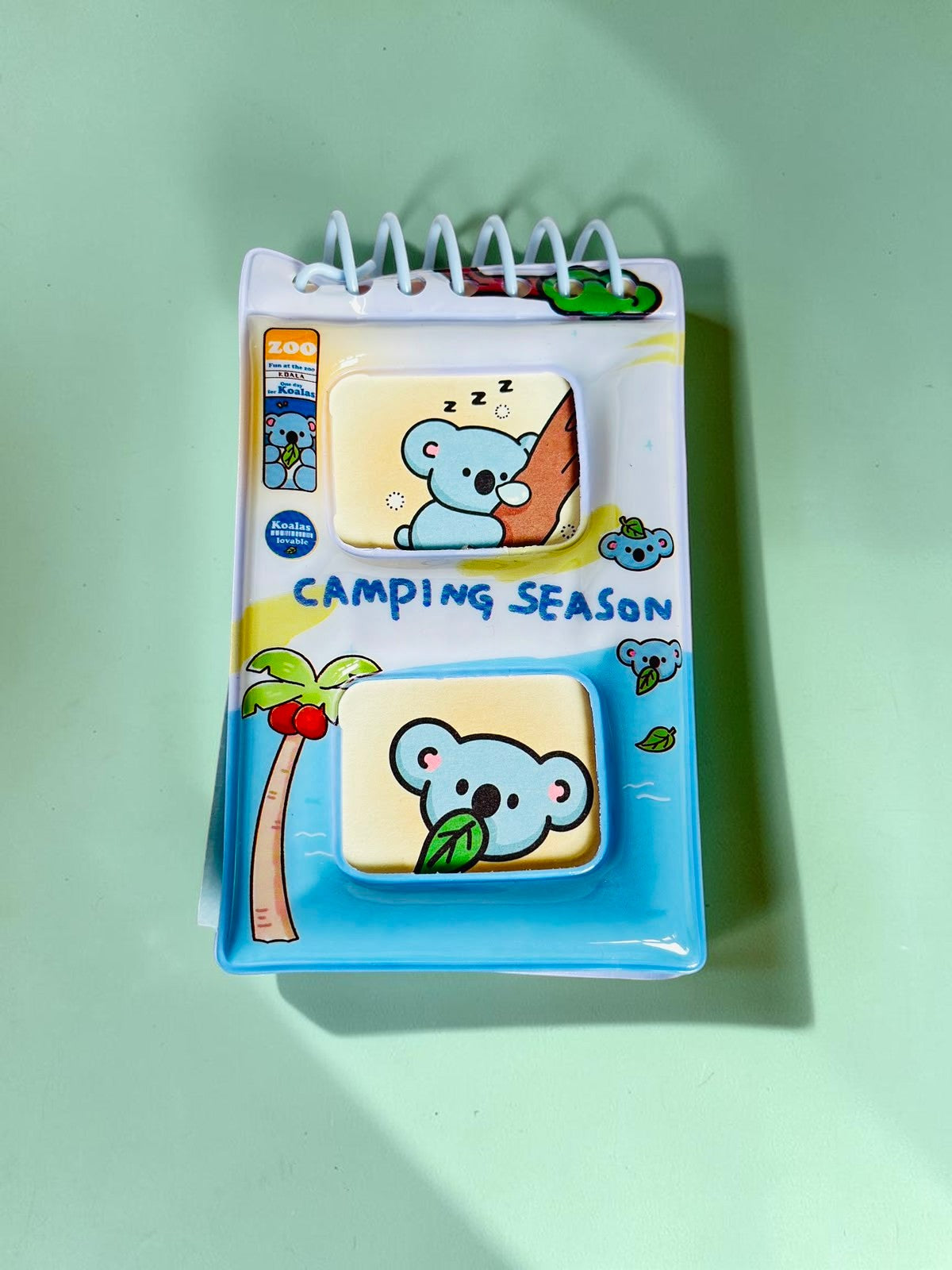 Miso station Camping Season pocket notebook with a blue koala design and spiral binding on a white textured surface.