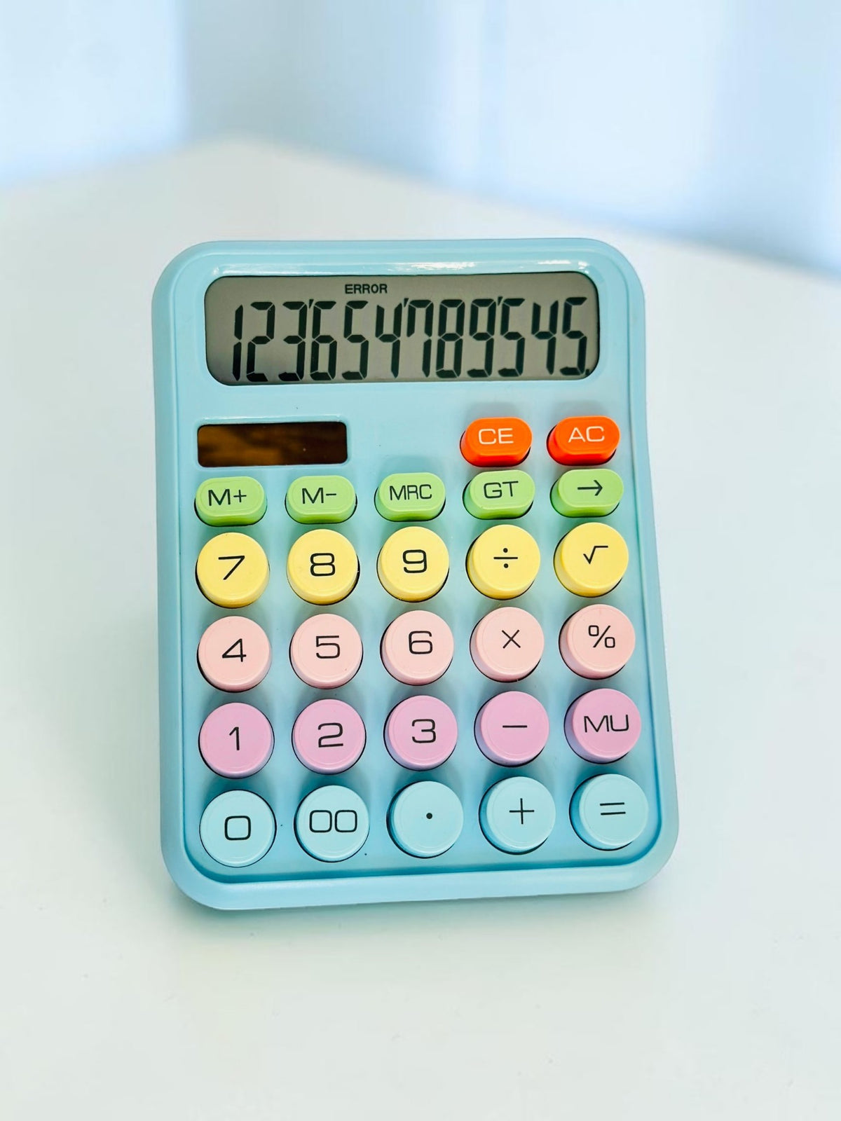 Miso station pastel desktop calculator with large, multi-colored circular buttons and a clear LCD display screen.