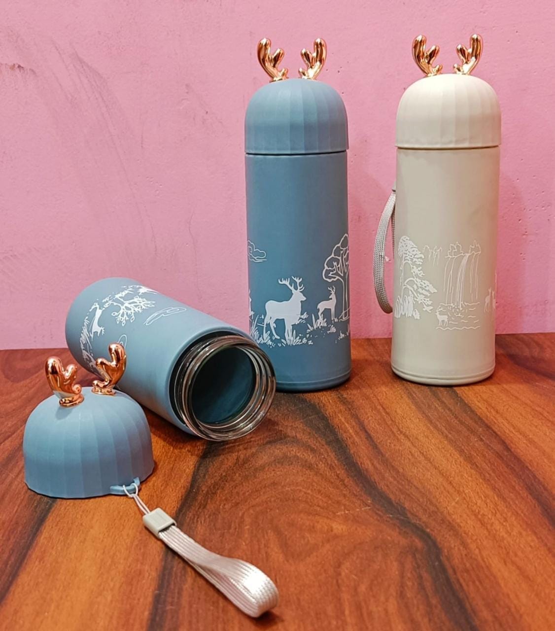 Miso station insulated stainless steel water bottles in blue and beige with rose gold reindeer antler lids.