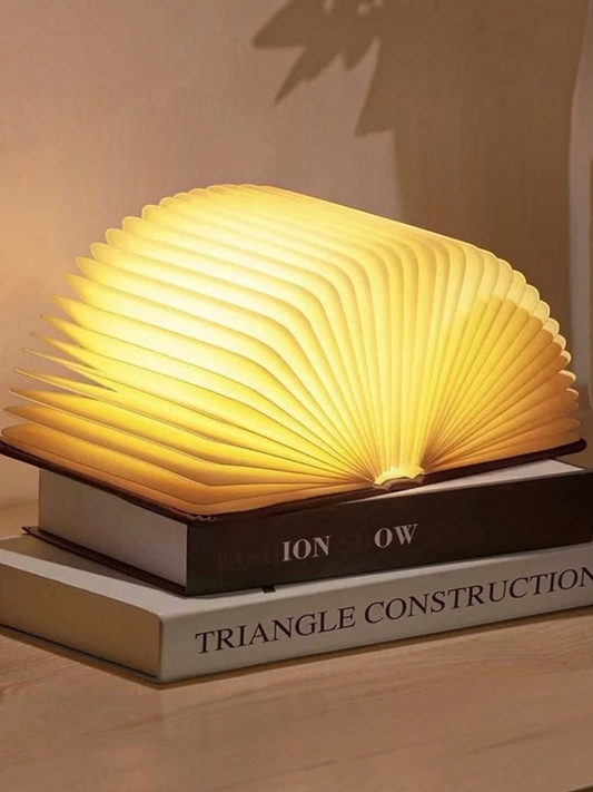 Miso station rechargeable book lamp with warm glowing pages shaped like an open book on a nightstand