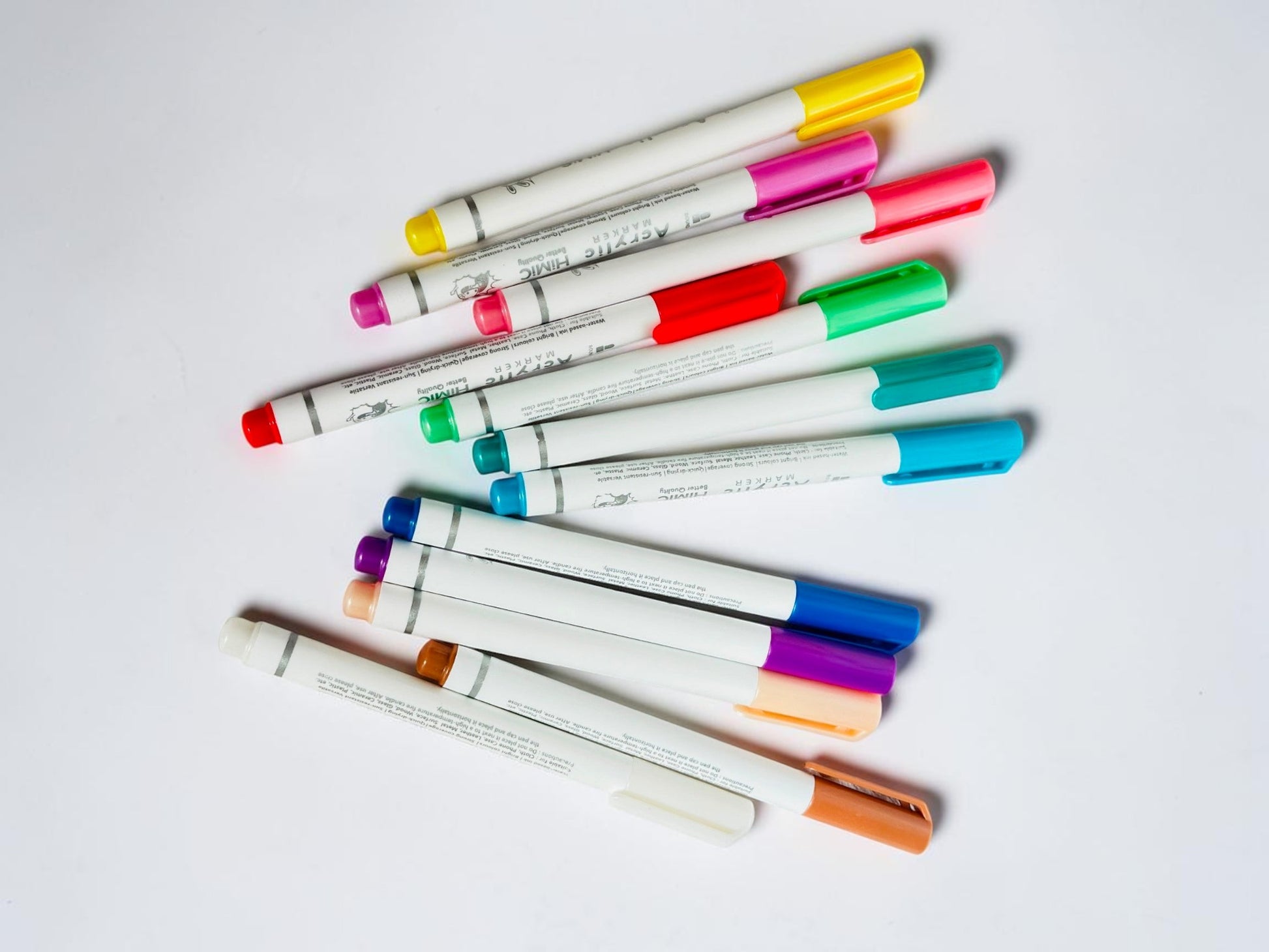 Miso station 12-piece set of vibrant acrylic paint markers on a white textured background