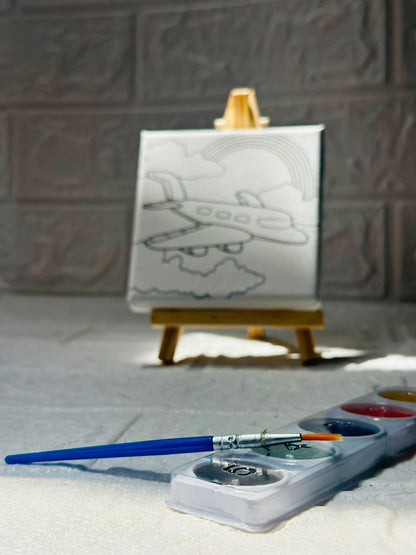 Miso station airplane painting kit with a pre-printed canvas on a wooden easel, paint palette, and brush.