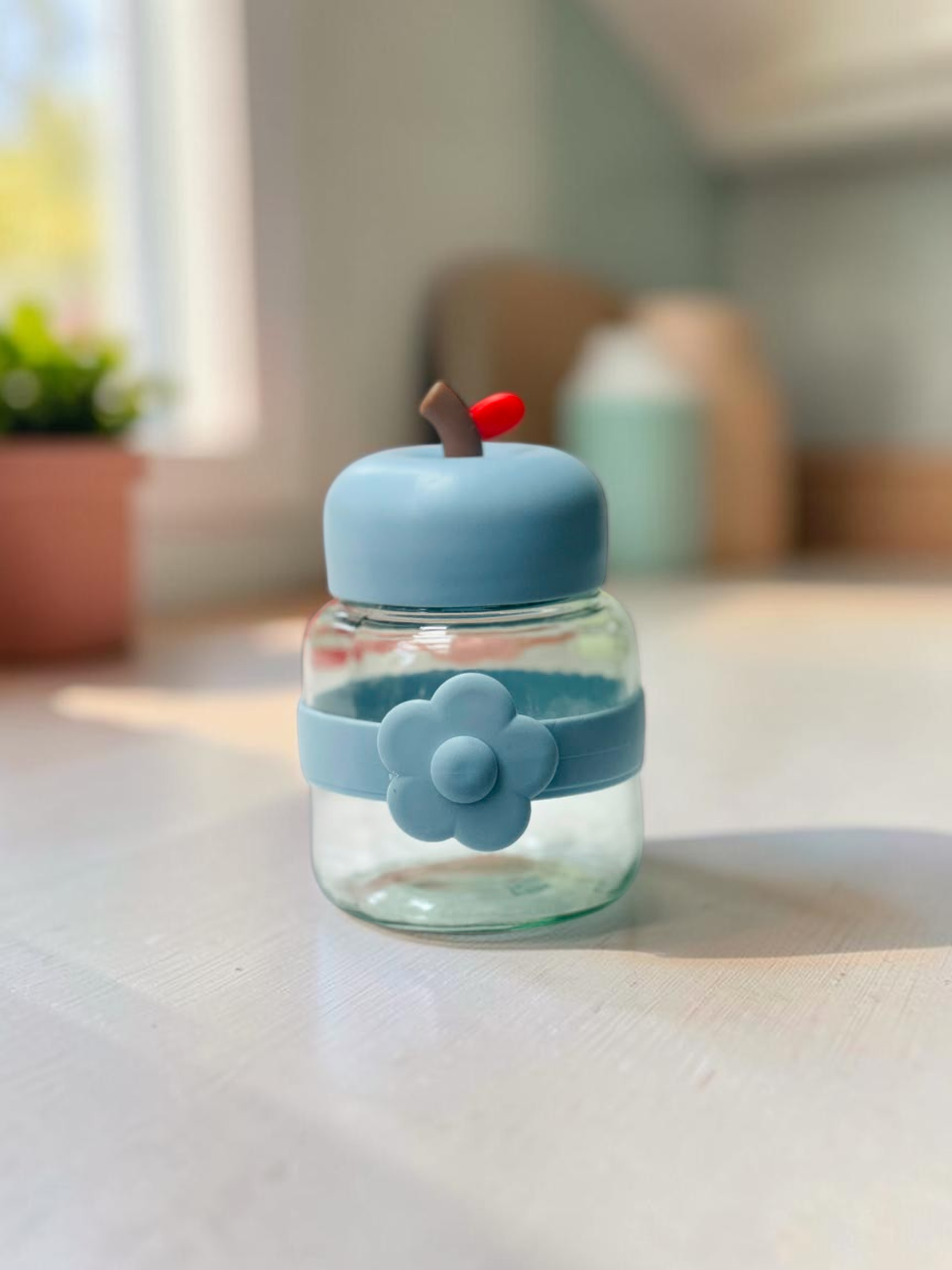 Miso station apple-shaped glass storage jar in light blue with a decorative flower silicone band and stem lid