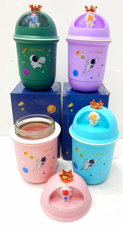 Miso station astronaut themed desktop storage bins in green, purple, pink, and blue with crown-topped dome lids.