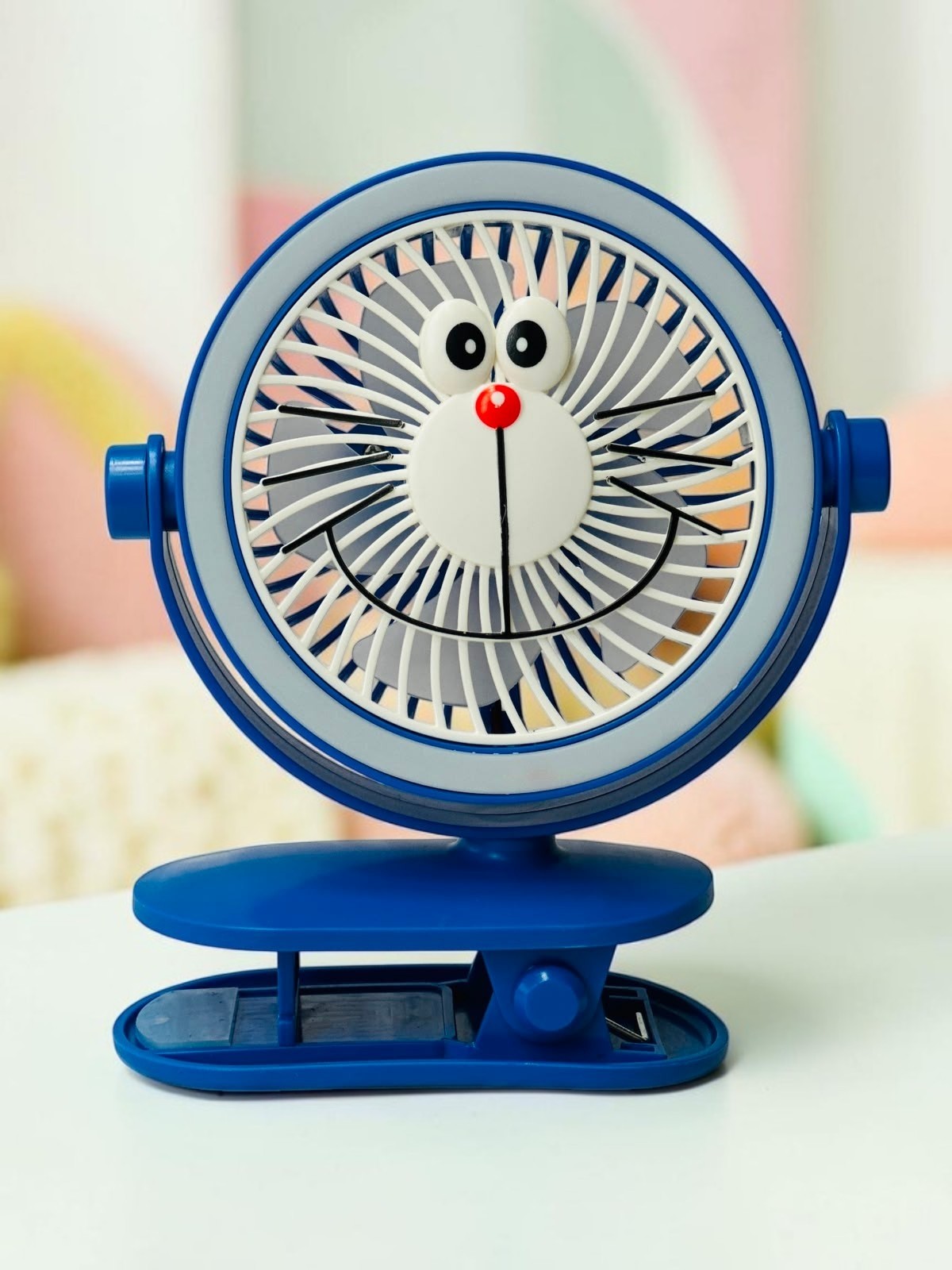 Miso station blue character clip-on desk fan with a friendly face design and adjustable head for portable cooling.