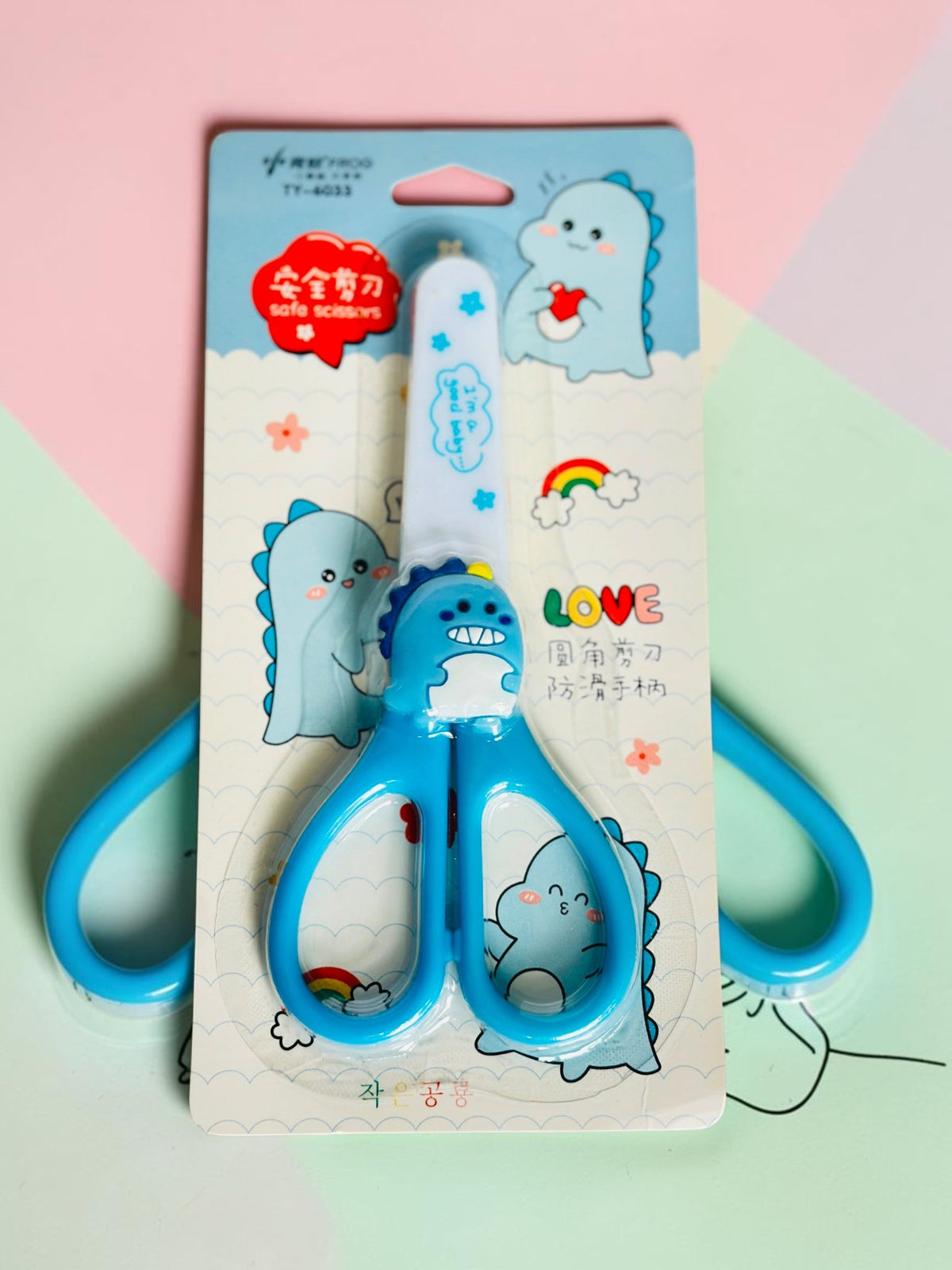 Miso station blue dinosaur-themed children's safety scissors with rounded tips and ergonomic handles in packaging.