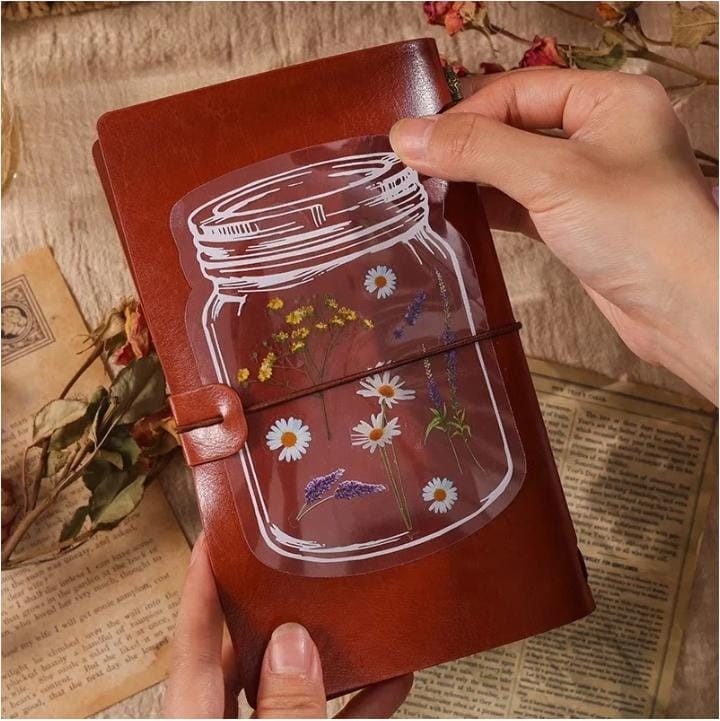 Miso station botanical sticker featuring pressed wildflowers in a mason jar design on a brown leather journal cover