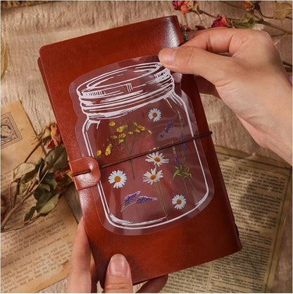 Miso station botanical sticker featuring pressed wildflowers in a mason jar design on a brown leather journal cover