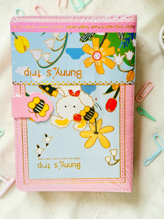Miso station Bunny Trip journal with a pink cover, whimsical bunny and garden illustration, and a bee magnetic clasp.