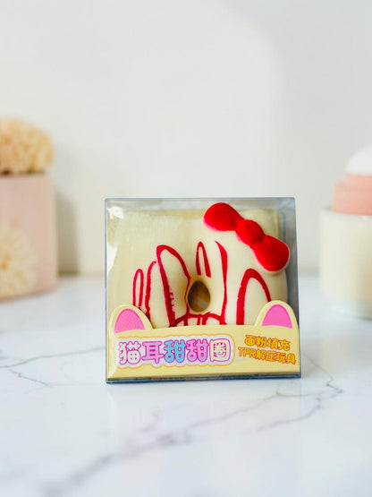 Miso station cat ear donut stress relief toy in clear packaging with red icing and a red bow on a white background