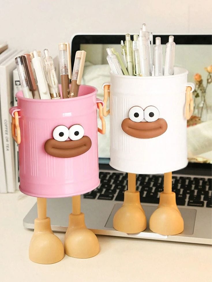 Miso station pink and white cartoon character pen holders with expressive faces and playful legs on a desk