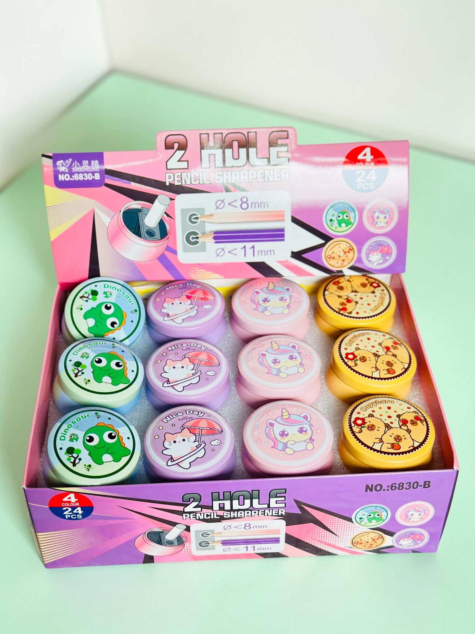 Miso station 2-hole pencil sharpeners in a display box featuring cute dinosaur, kitten, unicorn, and capybara designs.