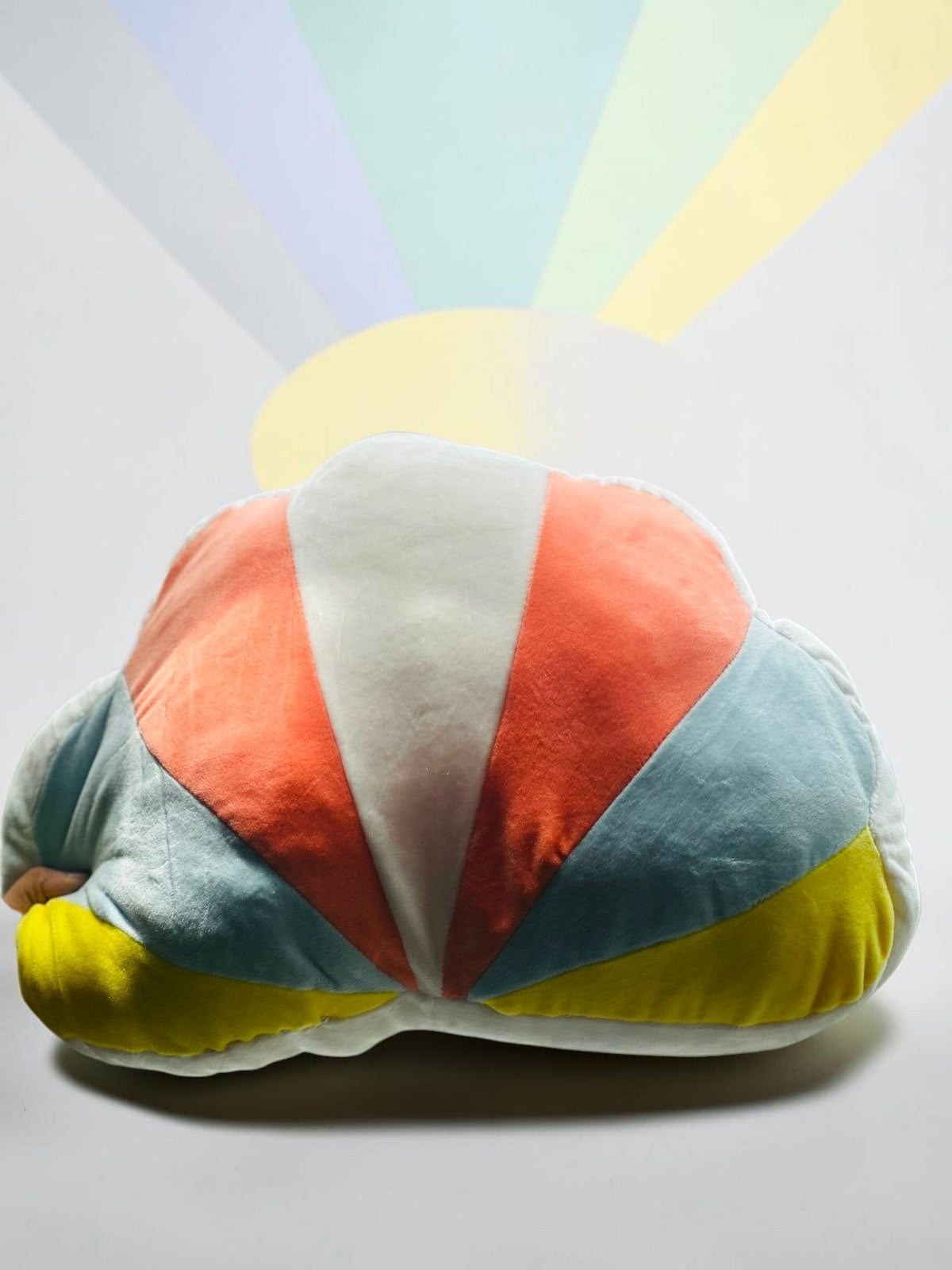 Miso station plush cloud-shaped throw pillow with a vibrant orange, sky blue, and yellow sunburst pattern