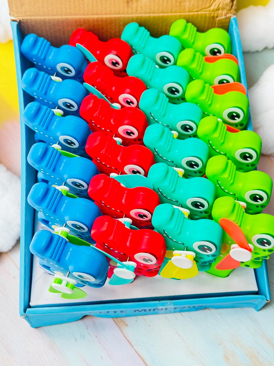 Miso station handheld crocodile mini fans in blue, red, and green, featuring a manual squeeze-operated blade design.