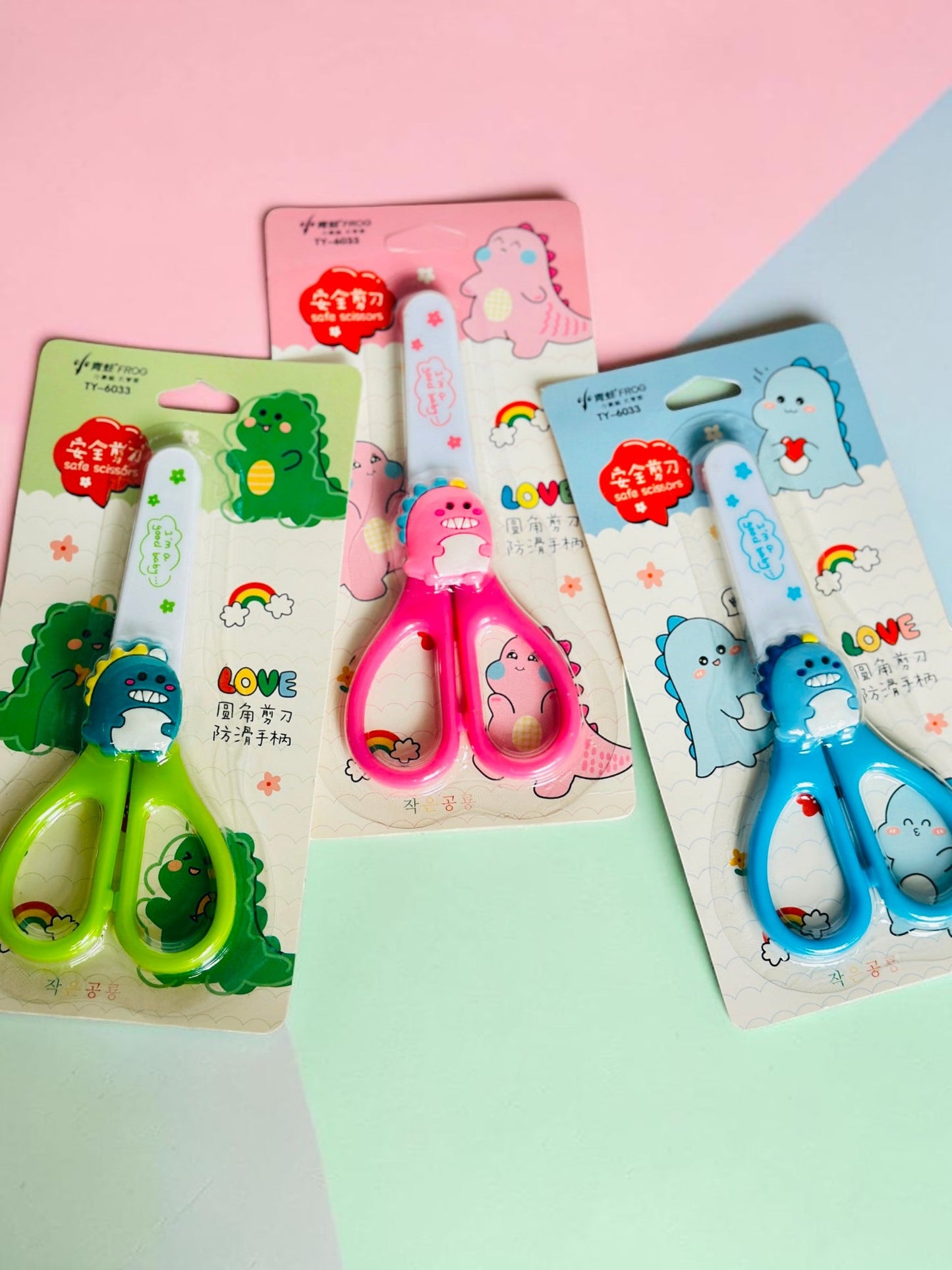Miso station dinosaur-themed children's safety scissors in green, pink, and blue with rounded tips and ergonomic grips.