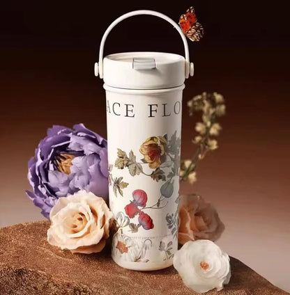 Miso station cream stainless steel insulated tumbler with floral botanical print, carry handle, and leak-proof lid.