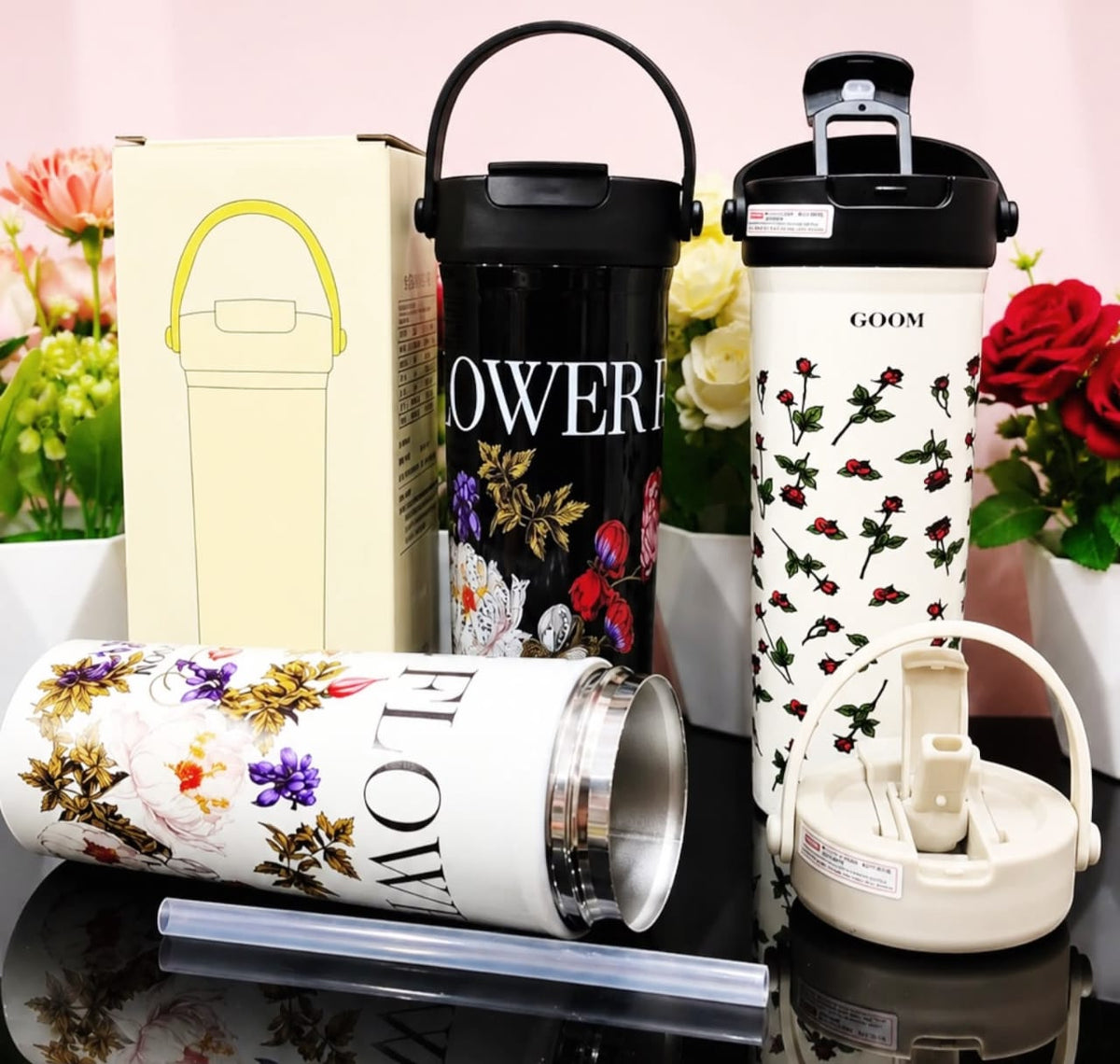Miso station floral insulated stainless steel tumblers in black and cream with carry handles, lids, and straws.