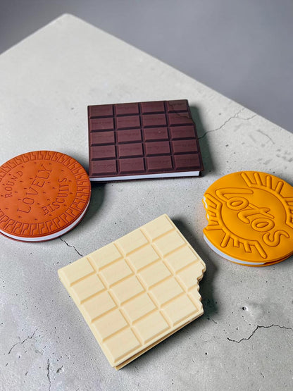 Miso station food-shaped notebooks featuring realistic chocolate bar and biscuit designs with textured PVC covers.