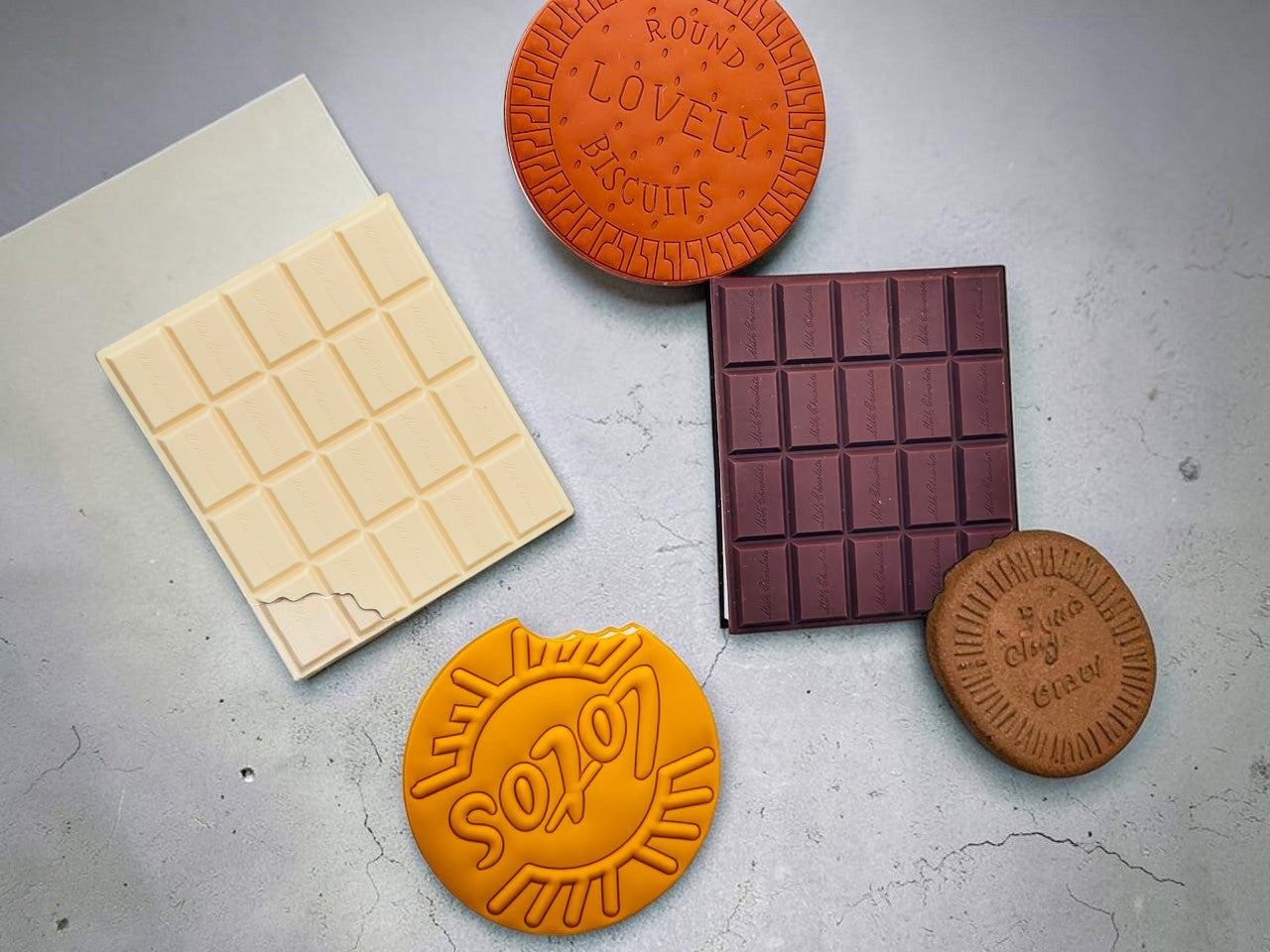 Miso station novelty food-shaped notebooks with realistic PVC covers resembling chocolate bars and round biscuits.