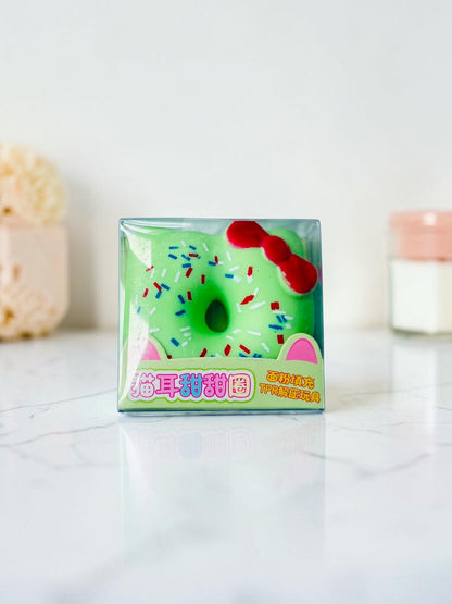 Miso station green cat ear donut stress relief squeeze toy with red bow and colorful sprinkles in clear packaging