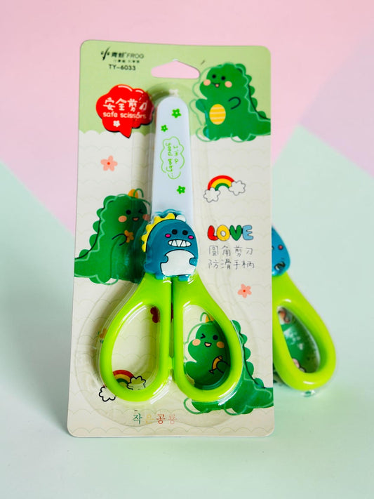 Miso station green dinosaur-themed children's safety scissors with rounded tips and ergonomic handles in packaging.