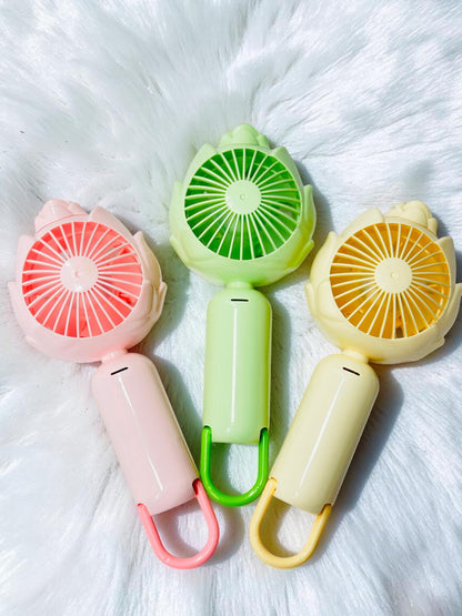Miso station lotus-inspired portable handheld fans in pastel pink, mint green, and sunny yellow with bottom loops.