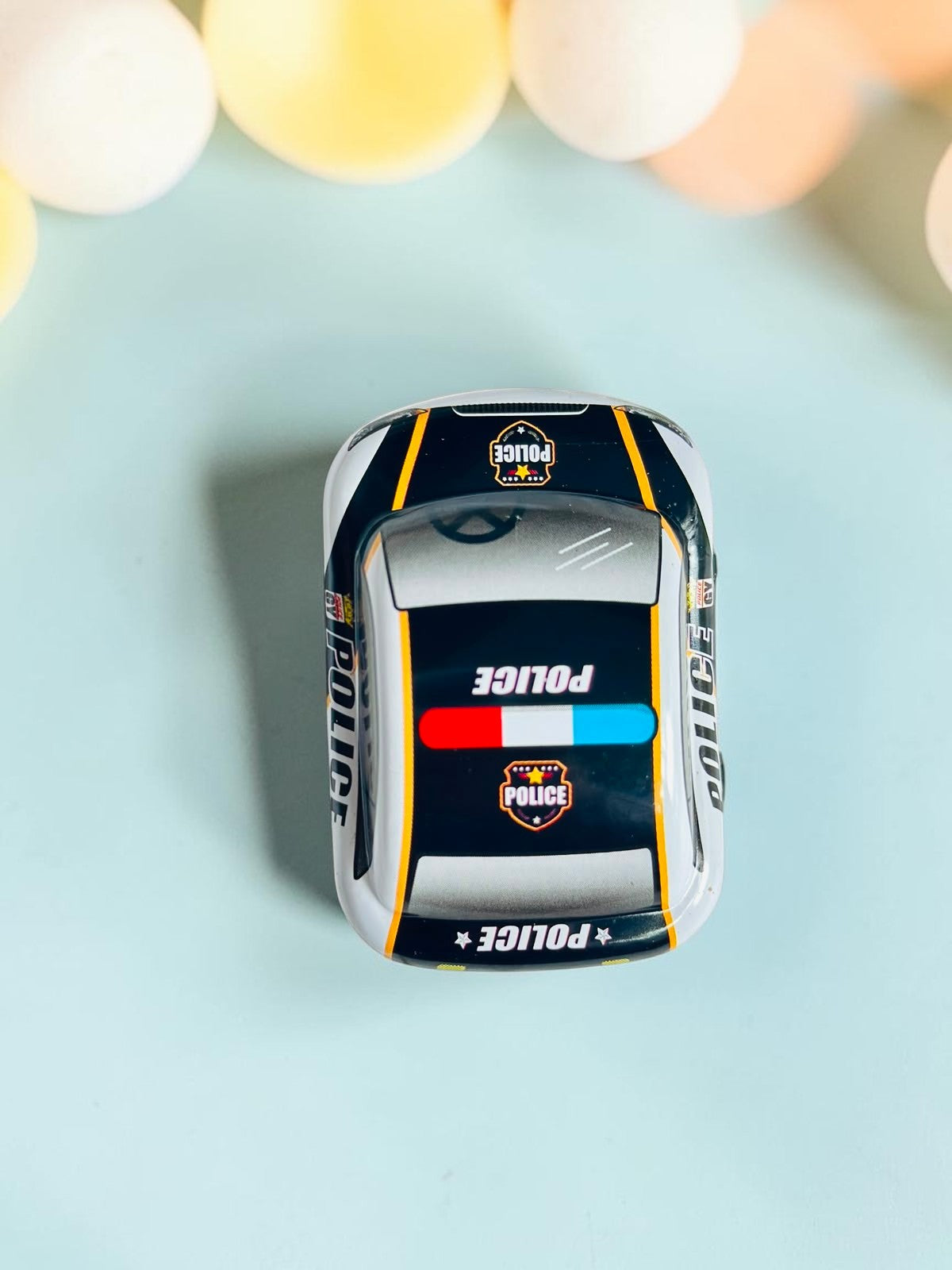 Miso station metal police toy car viewed from above featuring black and white paint with emergency light graphics