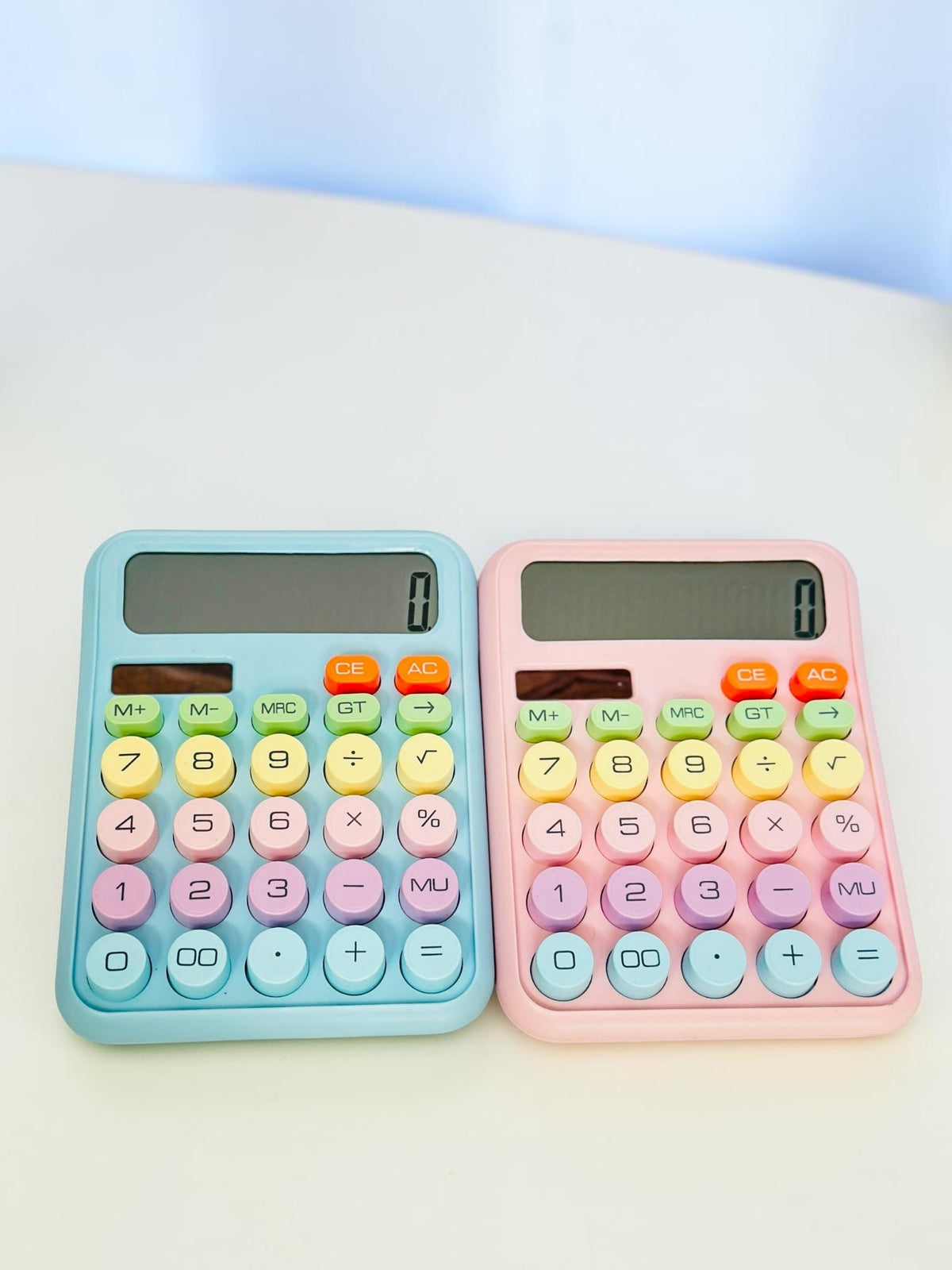 Miso station pastel desktop calculators in blue and pink with large circular buttons and clear LCD displays.