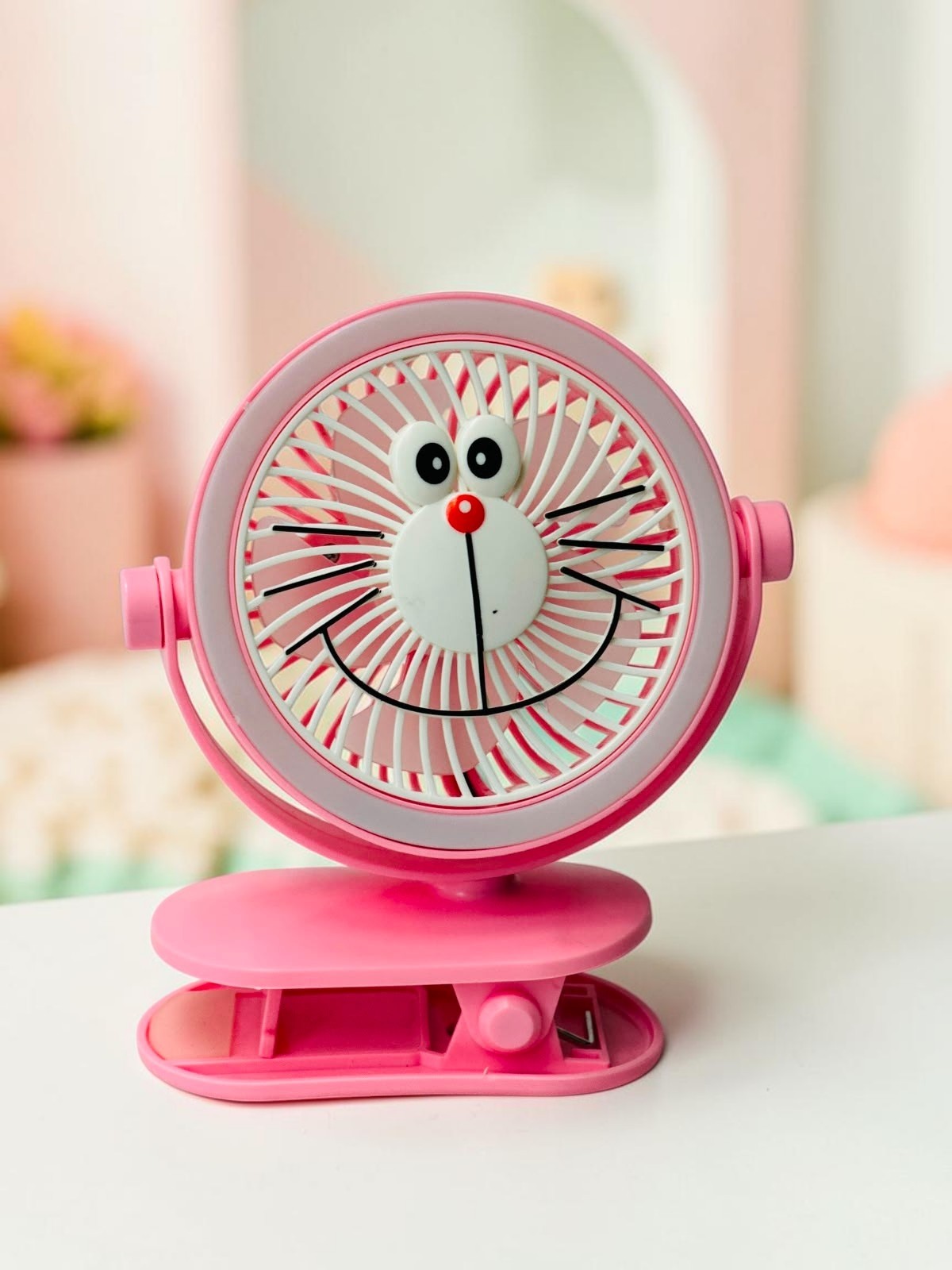 Miso station pink character clip-on desk fan with a playful face design and adjustable head for portable cooling.