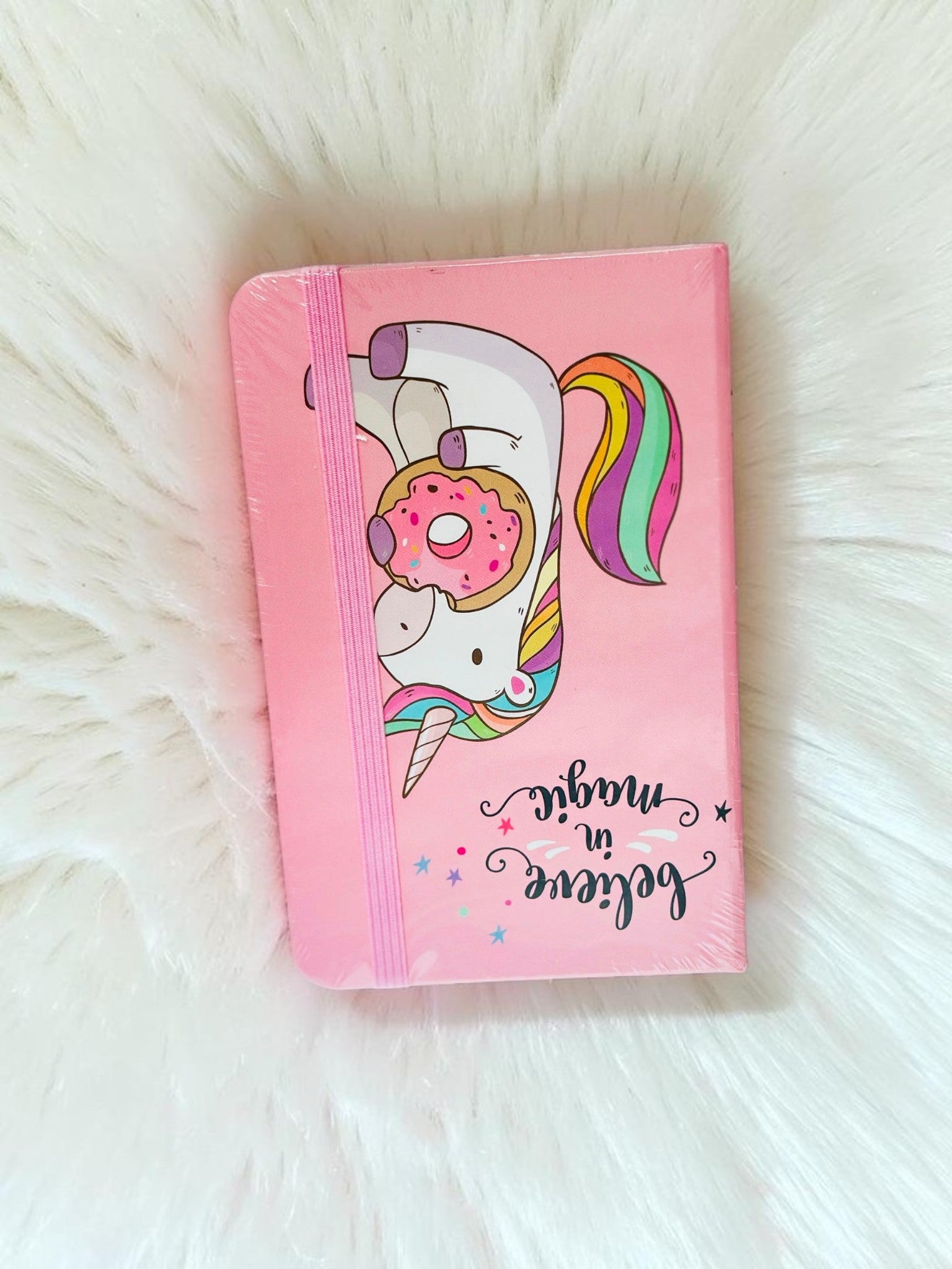 Miso station pink unicorn journal with a donut illustration, rainbow mane, and elastic band closure.