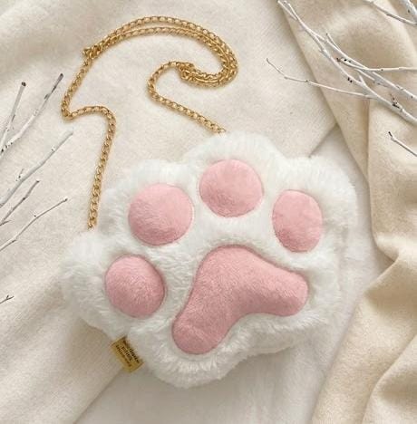 Miso station plush white cat paw crossbody bag with soft pink pads and a gold-tone chain strap on a cream background