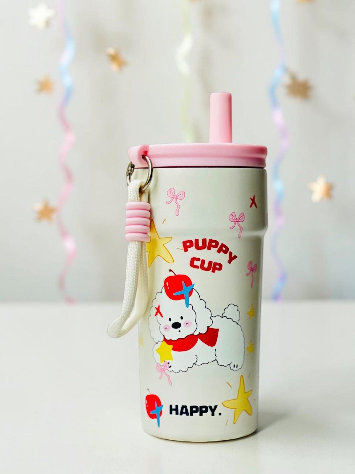 Miso station cream stainless steel tumbler with puppy illustration, pink lid, straw, and carrying strap.