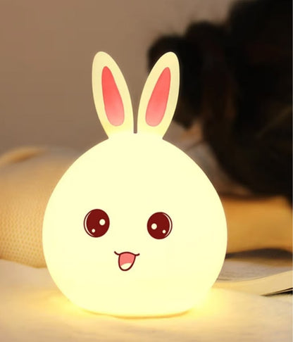 Miso station rabbit shaped silicone LED night light with a warm glow and cute face design on a bedside table