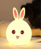 Miso station rabbit shaped silicone LED night light with a warm glow and cute face design on a bedside table