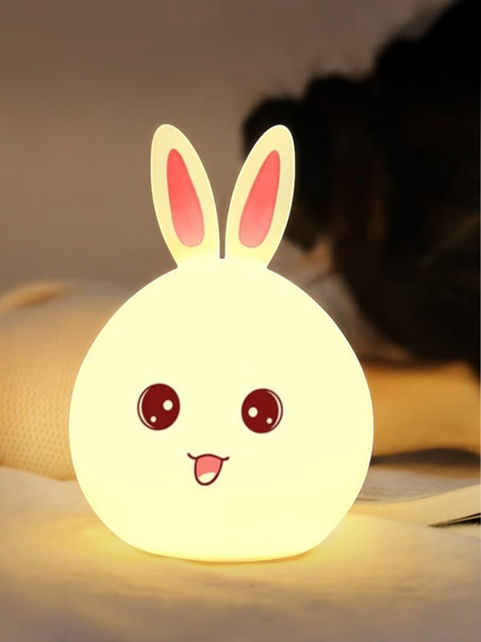 Miso station rabbit shaped silicone LED night light with a warm glow and cute face design on a bedside table