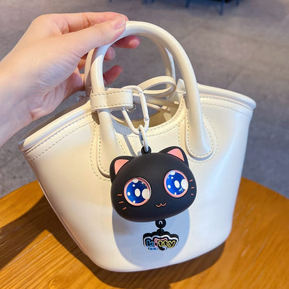 Miso station silicone cartoon cat keychain with large blue eyes attached to a small white handbag
