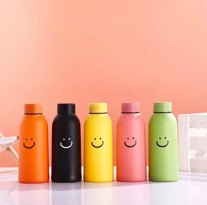 Miso station insulated water bottles in orange, black, yellow, pink, and green with a smiley face design.
