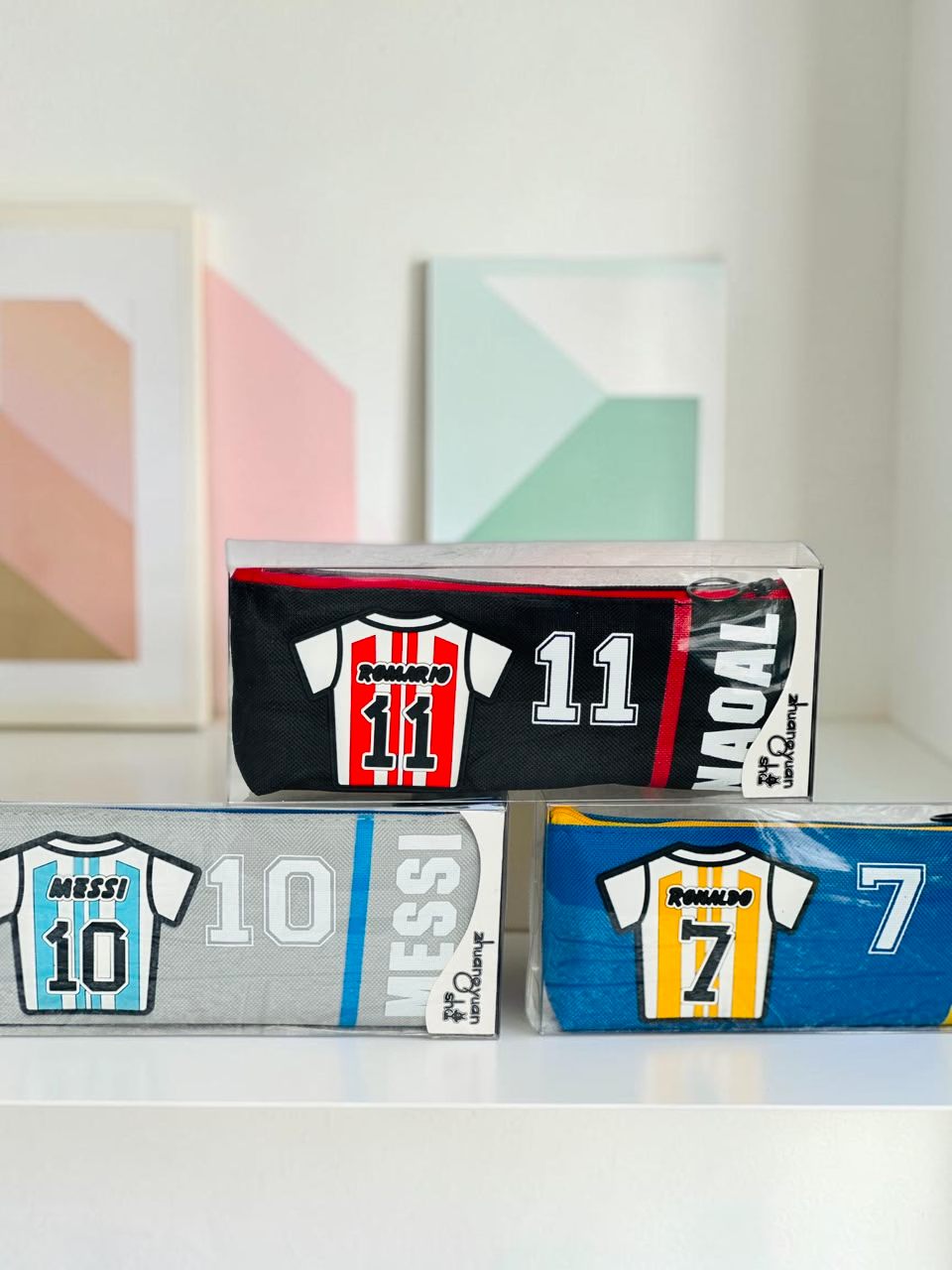 Miso station soccer jersey themed pencil cases featuring Messi, Romario, and Ronaldo designs in a clear display box.