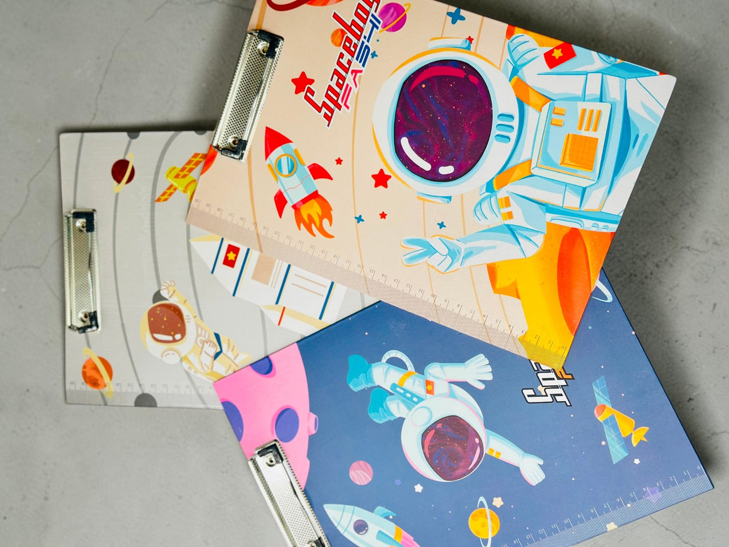 Miso station space-themed clipboards with astronaut and rocket graphics, featuring metal clips and integrated rulers.
