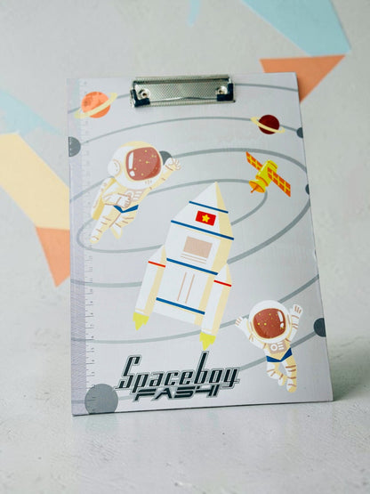 Miso station space-themed clipboard featuring astronauts, a rocket, and a built-in ruler on a grey background.