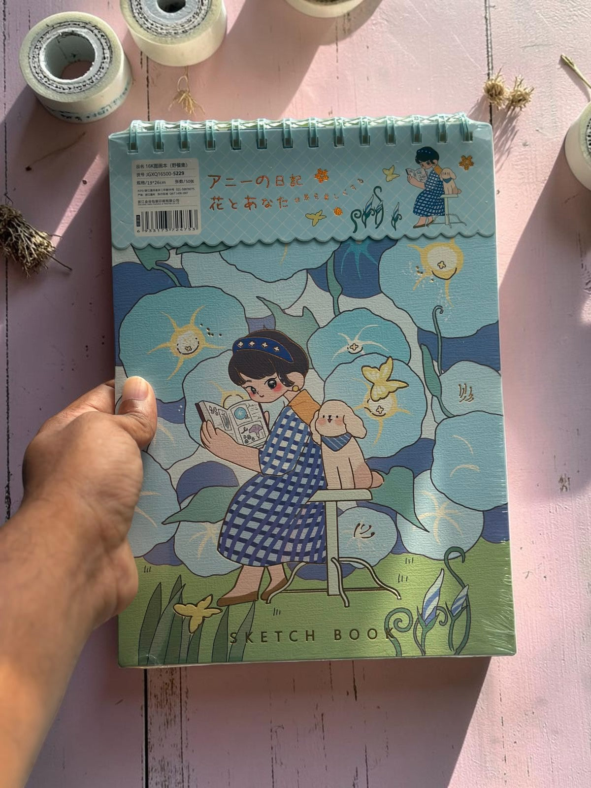 Miso station 16K spiral bound sketchbook with a whimsical blue floral cover featuring a girl reading with a dog