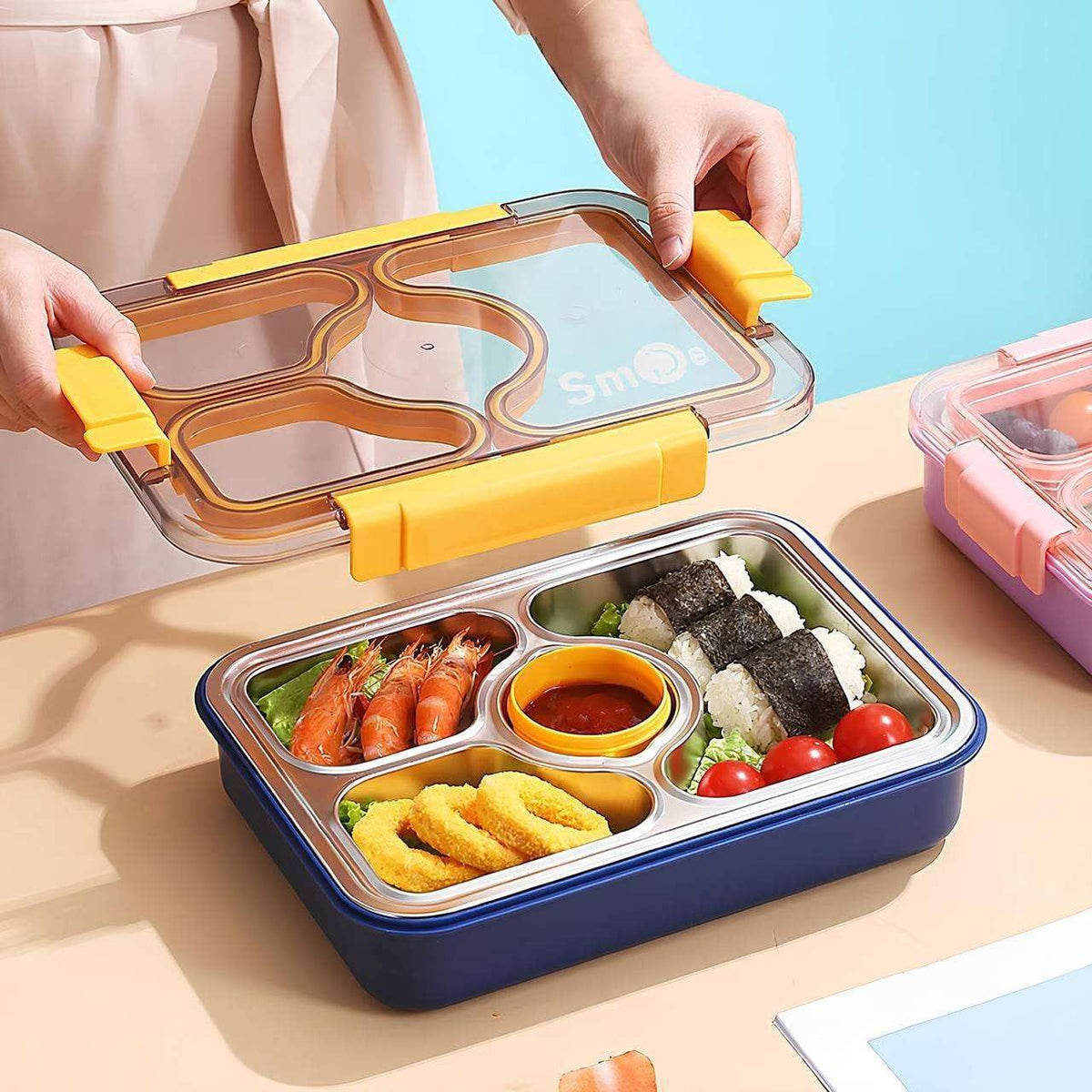 Miso station multi-compartment lunch box with stainless steel tray, yellow locking lid, and included utensils.
