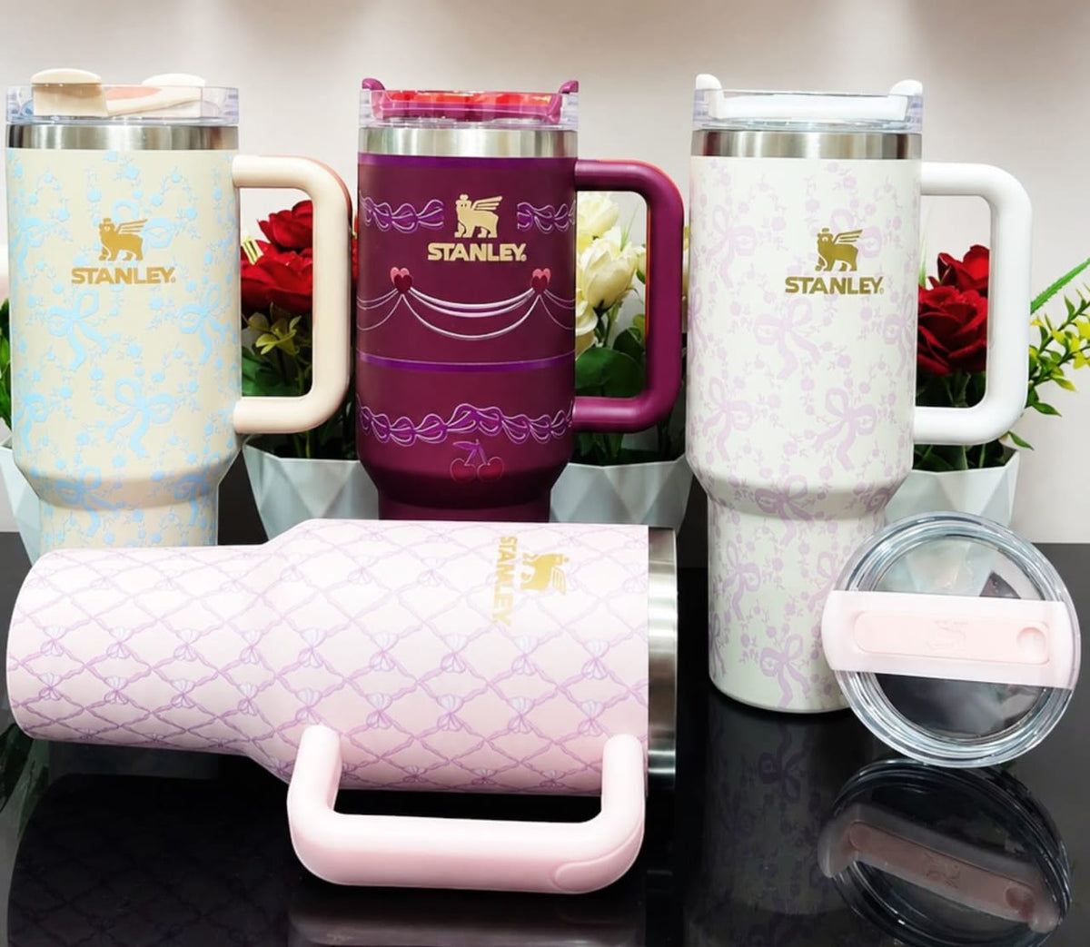 Miso station Stanley Quencher H2.0 tumblers in various colors with bow, ribbon, and cherry patterns and FlowState lids.