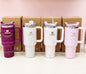 Miso station Stanley Quencher H2.0 tumblers in various pastel and dark purple shades with bow and cherry patterns.