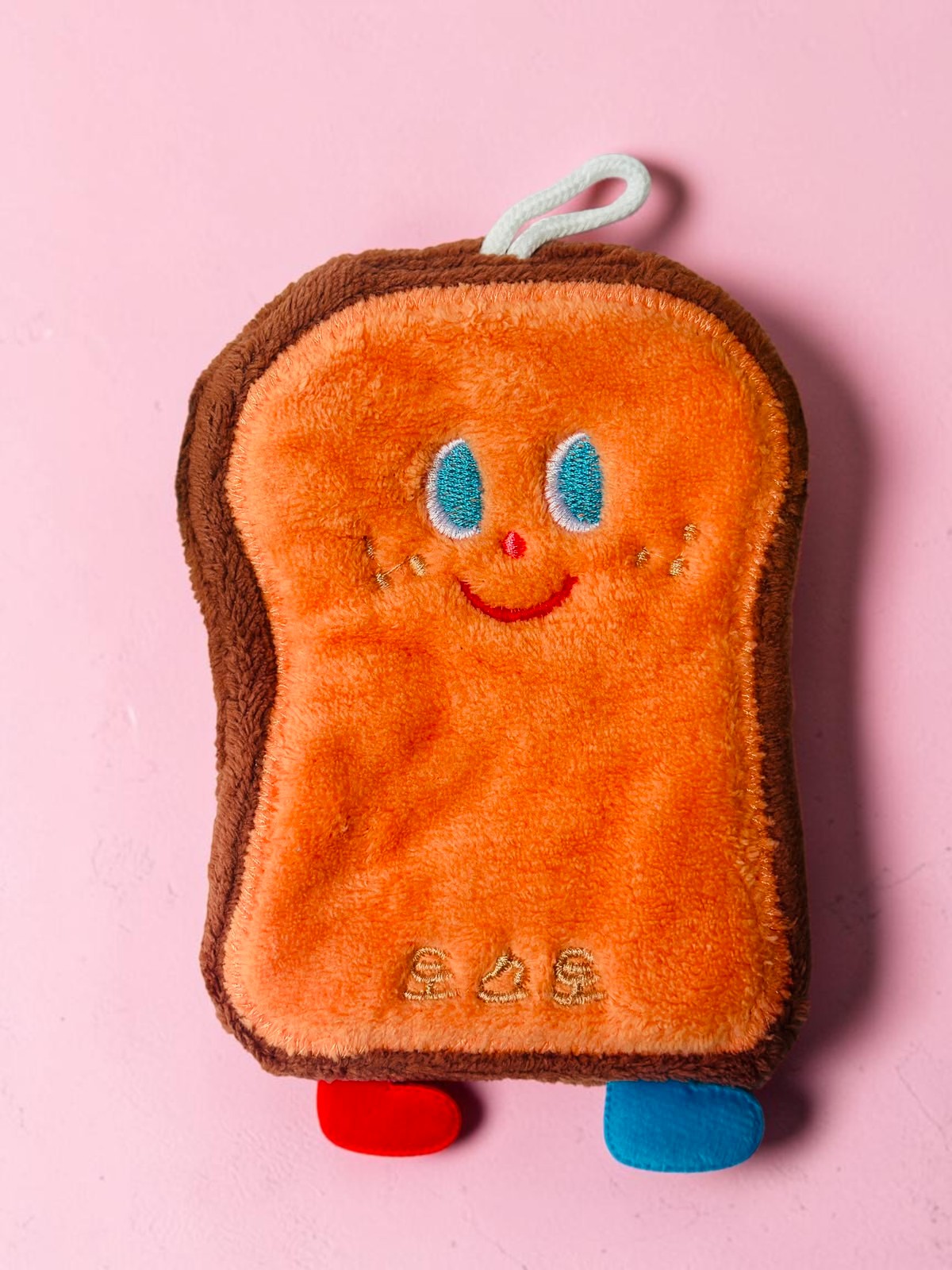 Miso station toast-shaped plush kitchen sponge with a cute embroidered face and hanging loop for easy storage.