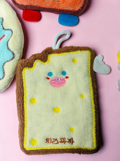Miso station toast-shaped kitchen sponge with a cute embroidered face, yellow and brown plush texture, and hanging loop.