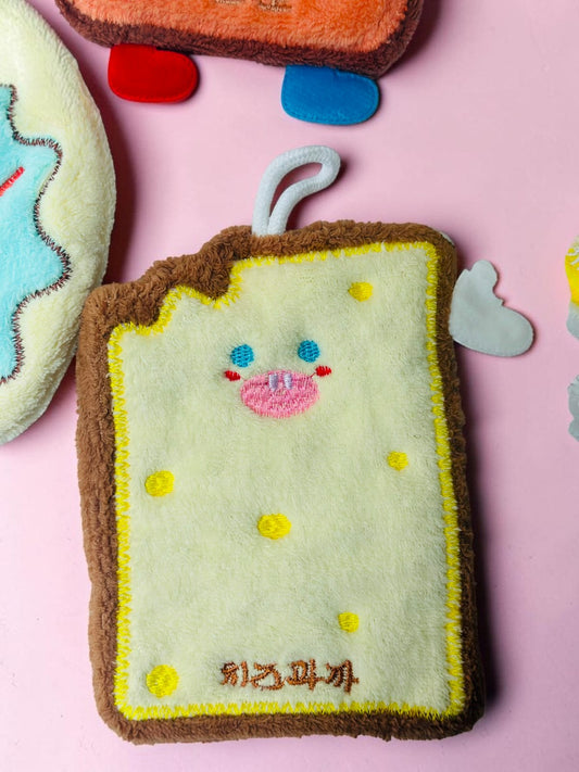Miso station toast-shaped kitchen sponge with a cute embroidered face, yellow and brown plush texture, and hanging loop.