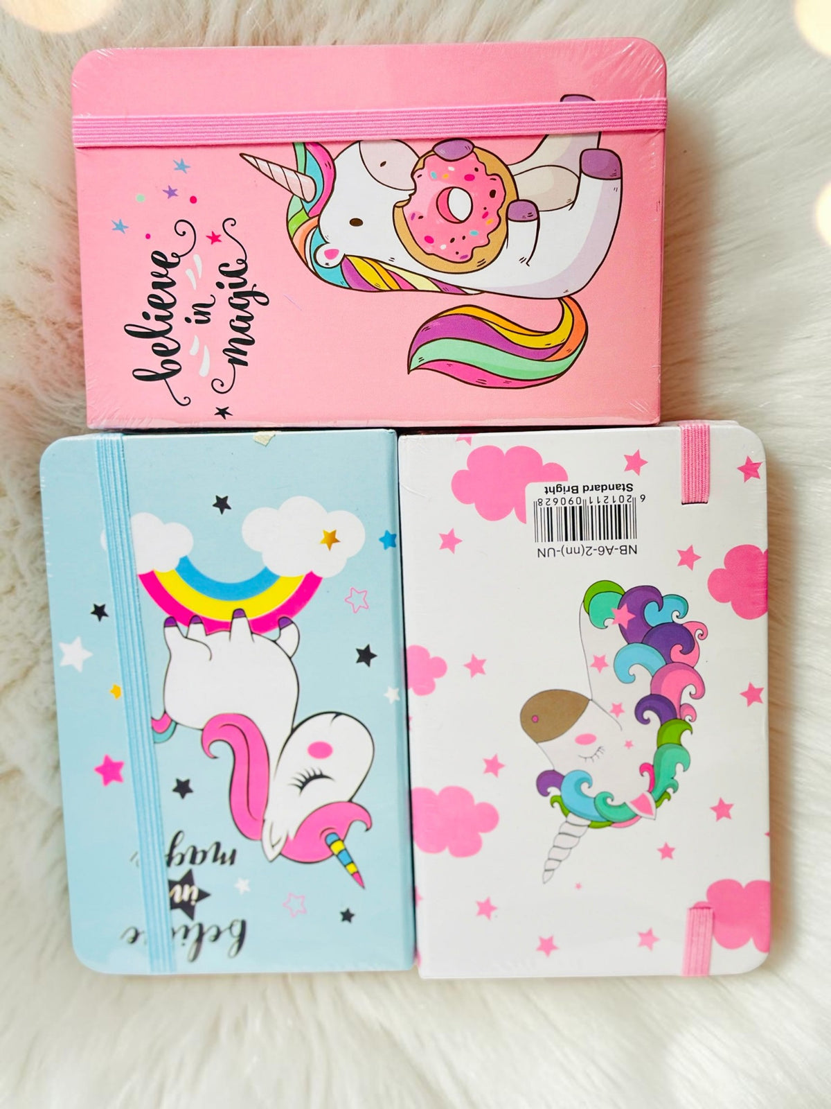 Miso station unicorn themed journals with elastic closures featuring colorful illustrations of unicorns and rainbows.